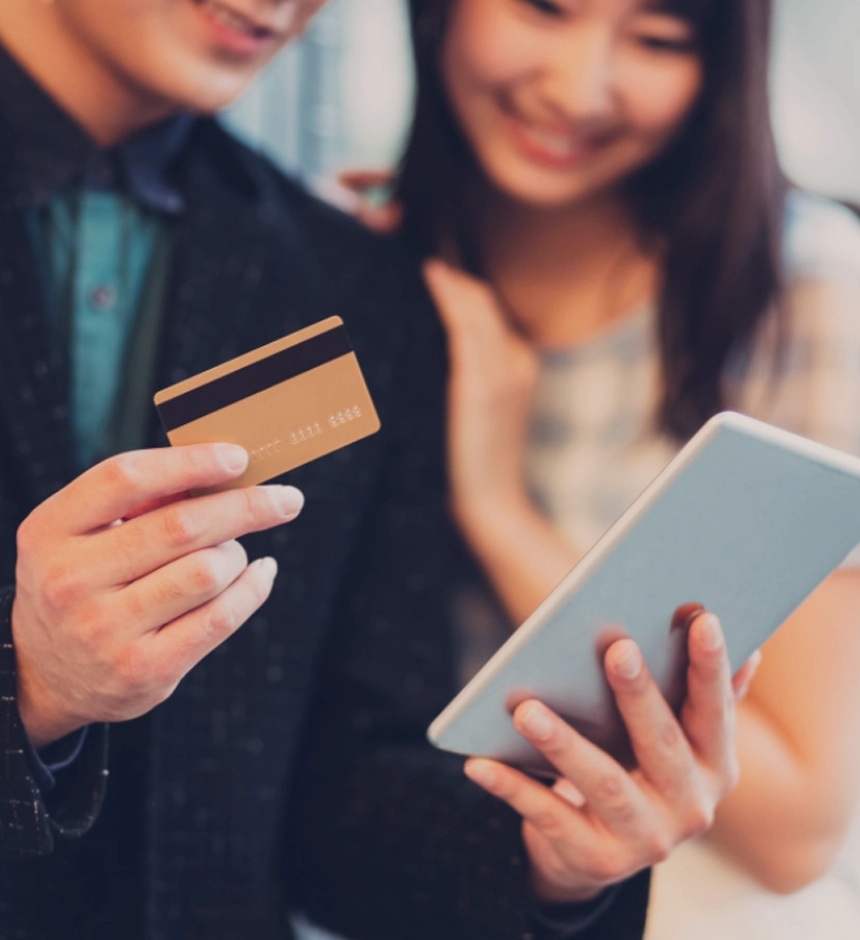 Couple using a credit card and tablet for online shopping.