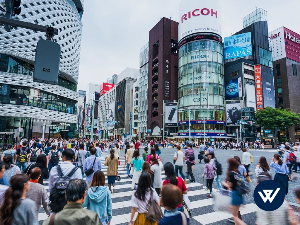 Busy Japanese street crossing with crowd and tall buildings, representing WeLink's expertise as a Japan market entry agency.