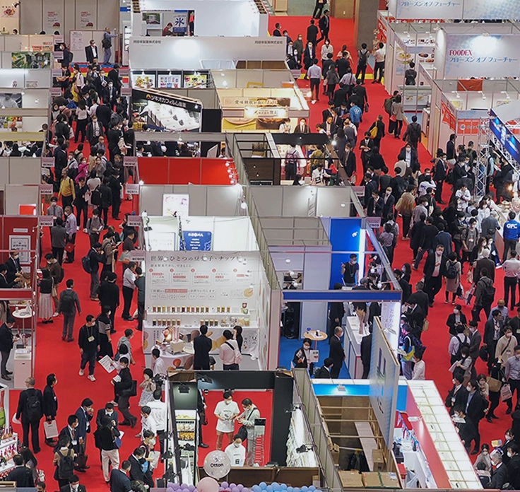 Overhead view of bustling booths at a Japanese trade expo, demonstrating WeLink's expertise in market entry strategy.